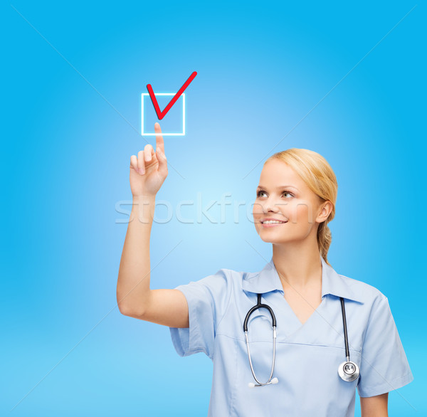 smiling doctor or nurse selecting Stock photo © dolgachov