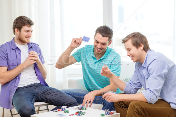 Boldog három férfi barátok játszik póker Stock fotó © dolgachov