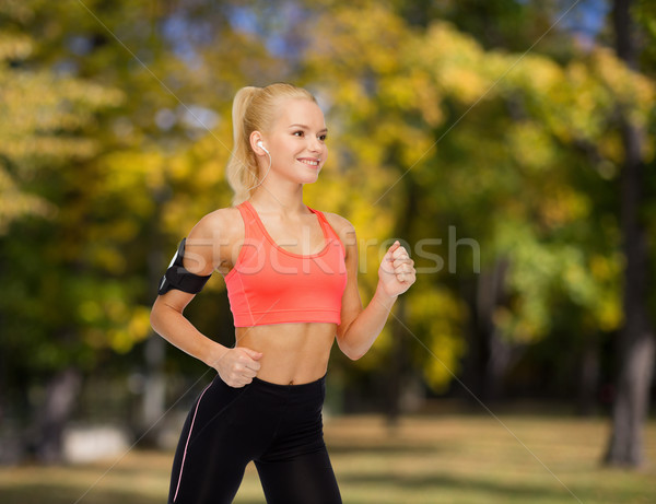 sporty woman running with smartphone and earphones Stock photo © dolgachov