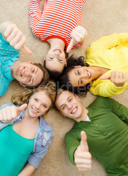 group of smiling people lying down on floor Stock photo © dolgachov