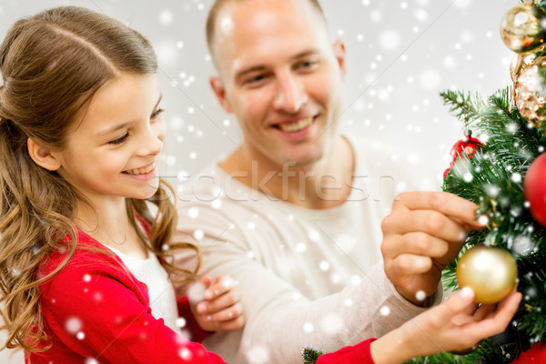 smiling family decorating christmas tree at home Stock photo © dolgachov