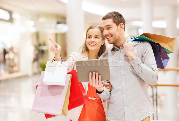 couple with tablet pc and shopping bags in mall Stock photo © dolgachov