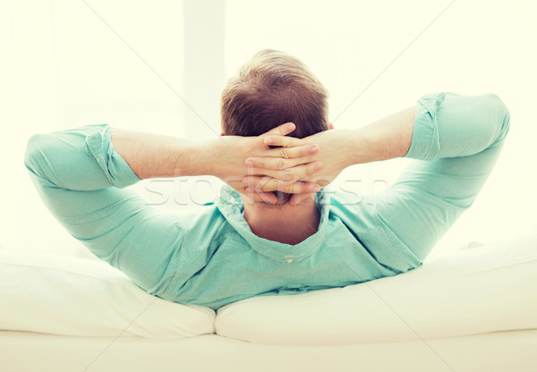 man lying or sitting on sofa at home from back Stock photo © dolgachov