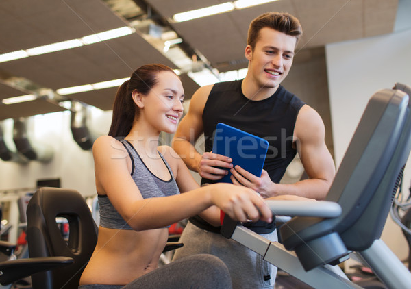 happy woman with trainer on exercise bike in gym Stock photo © dolgachov