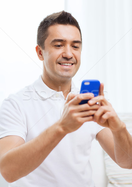 happy man with smartphone at home Stock photo © dolgachov