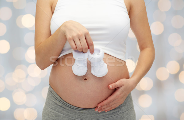 close up of pregnant woman with babys bootees Stock photo © dolgachov