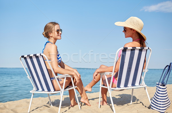 happy women sunbathing in lounges on beach Stock photo © dolgachov