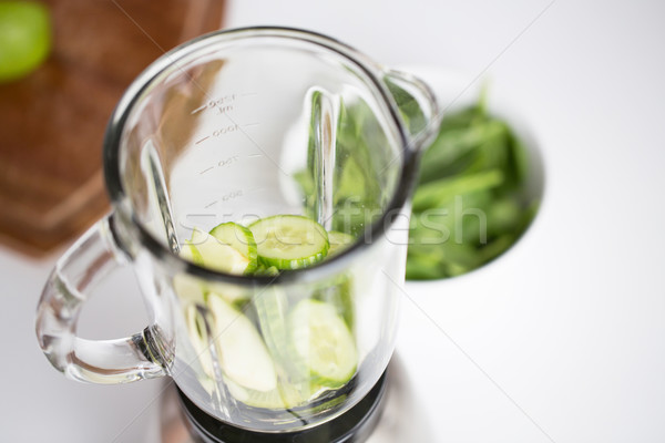 close up of blender jar and green vegetables Stock photo © dolgachov