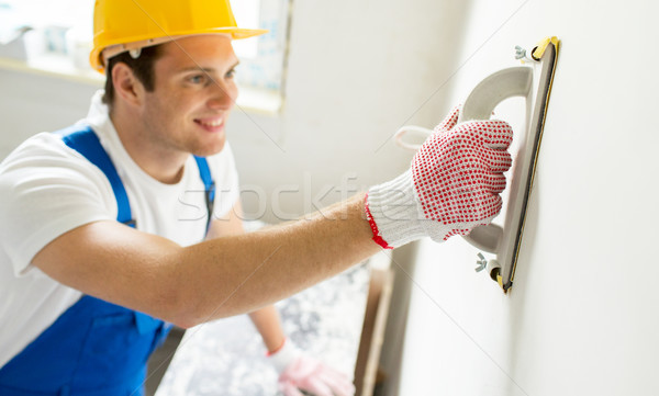 Stock photo: close up of builder working with grinding tool