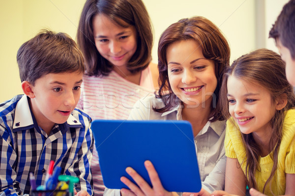 group of kids with teacher and tablet pc at school Stock photo © dolgachov