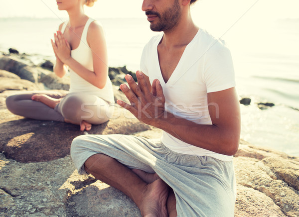 close up of couple making yoga exercises outdoors Stock photo © dolgachov