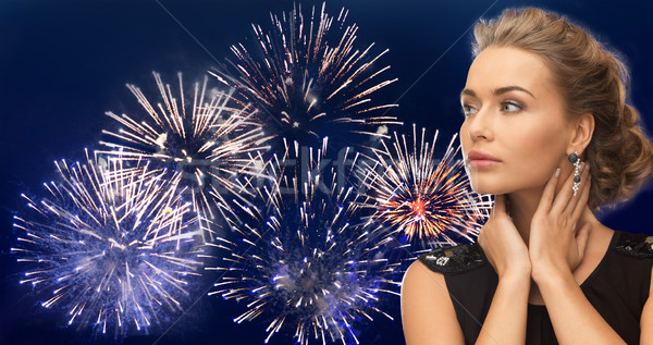 beautiful woman wearing earrings over firework Stock photo © dolgachov