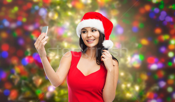 woman in santa hat taking selfie by smartphone Stock photo © dolgachov