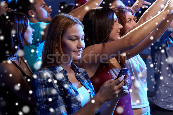 woman with smartphone texting message at concert Stock photo © dolgachov