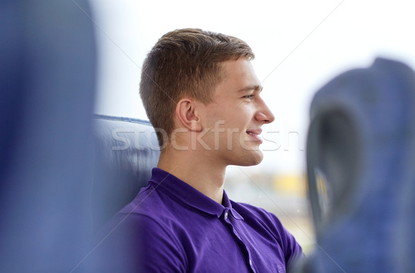 happy young man sitting in travel bus Stock photo © dolgachov