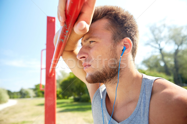 young man with earphones and horizontal bar Stock photo © dolgachov