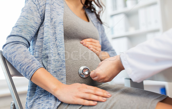 doctor with stethoscope and pregnant woman belly Stock photo © dolgachov