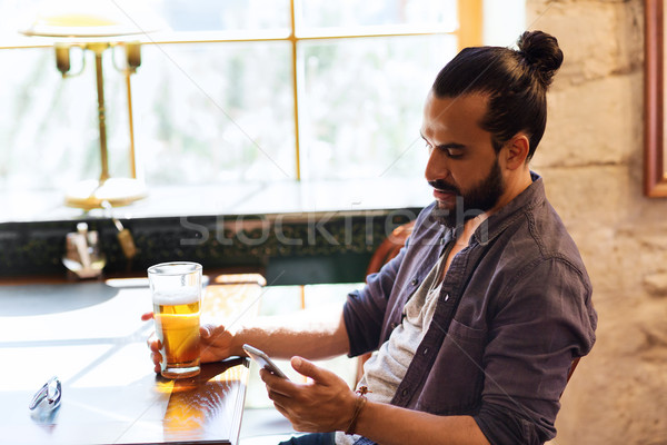 Stock photo: man with smartphone drinking beer at bar or pub