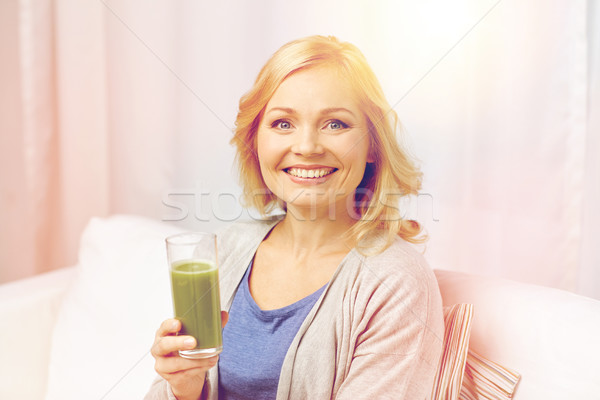 happy woman drinking green juice or shake at home Stock photo © dolgachov