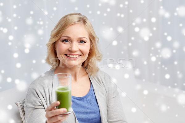 happy woman drinking green juice or shake at home Stock photo © dolgachov