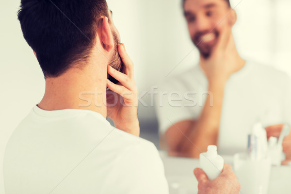 close up of man applying cream to face at bathroom Stock photo © dolgachov