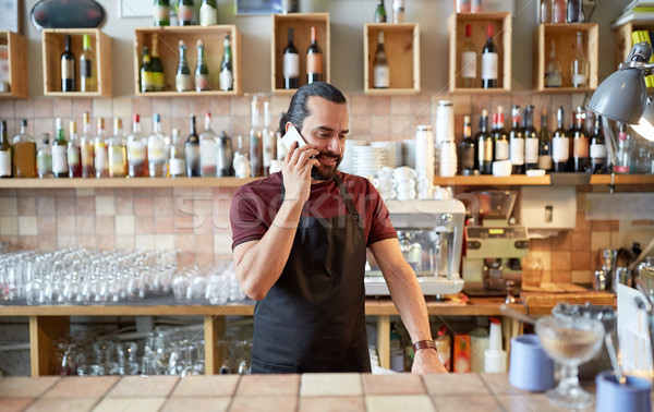 Felice uomo cameriere bar chiamando smartphone Foto d'archivio © dolgachov