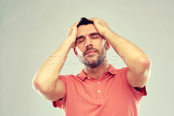 unhappy man suffering from head ache Stock photo © dolgachov