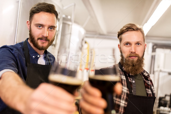 men drinking and testing craft beer at brewery Stock photo © dolgachov