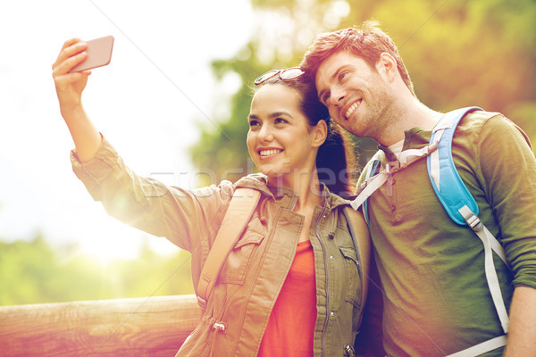 couple with backpacks taking selfie by smartphone Stock photo © dolgachov