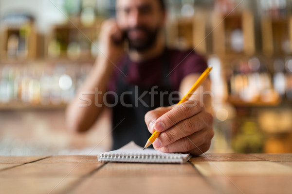 bartender with notebook and pencil at bar Stock photo © dolgachov