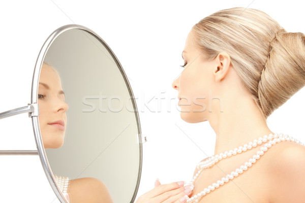 beautiful woman with pearl beads and mirror Stock photo © dolgachov
