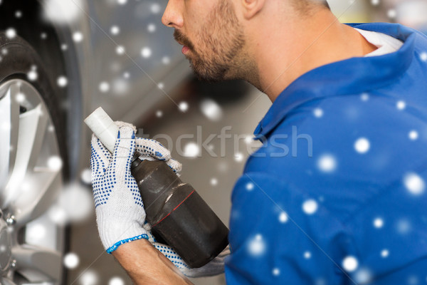 auto mechanic with screwdriver changing car tire Stock photo © dolgachov