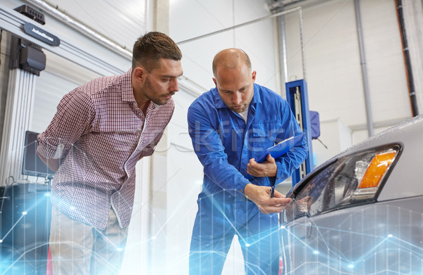 auto mechanic with clipboard and man at car shop Stock photo © dolgachov