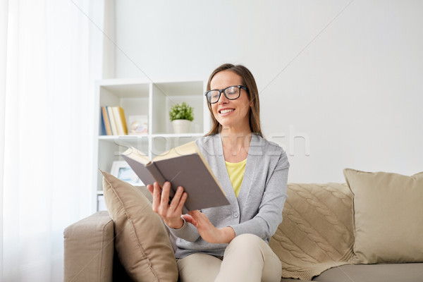 happy woman in glasses reading book at home Stock photo © dolgachov