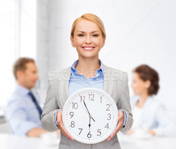 Stock photo: smiling businesswoman with wall clock