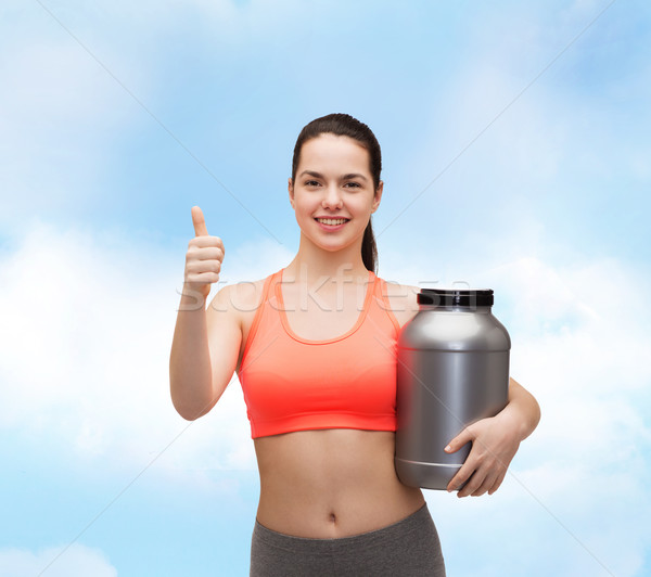 teenage girl with jar of protein showing thumbs up Stock photo © dolgachov