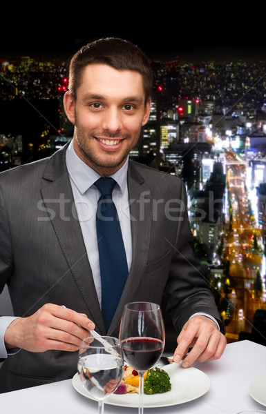 Uśmiechnięty człowiek jedzenie danie główne restauracji ludzi Zdjęcia stock © dolgachov