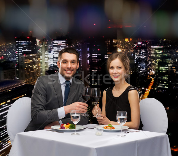 smiling couple eating main course at restaurant Stock photo © dolgachov