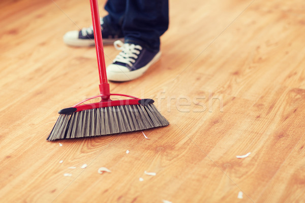 close up of male brooming wooden floor Stock photo © dolgachov