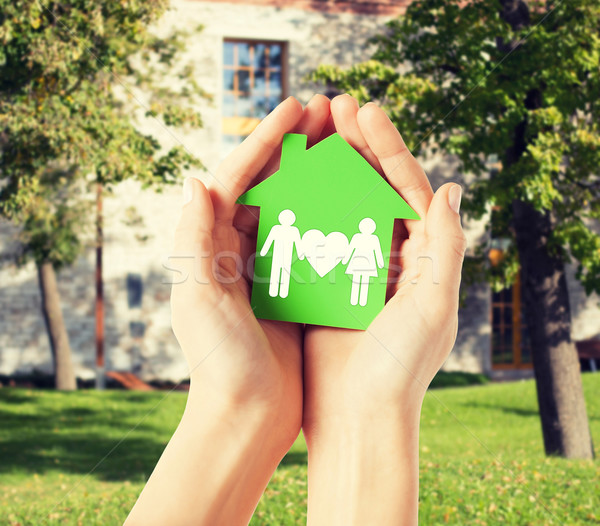 hands holding green house with family Stock photo © dolgachov