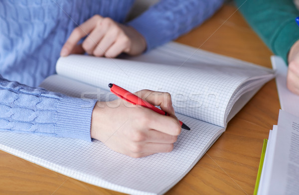 Stock photo: close up of student hands writing to notebook