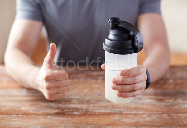 man with protein shake bottle showing thumbs up Stock photo © dolgachov