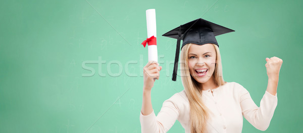 student in trencher cap with diploma over green Stock photo © dolgachov