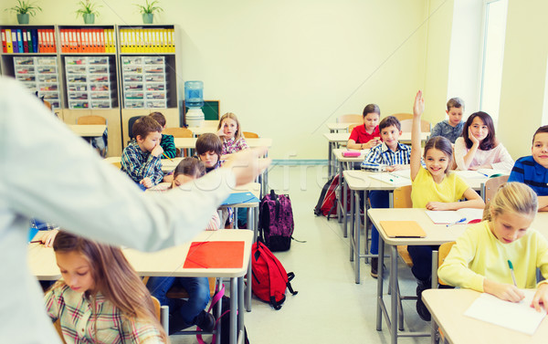 Stock photo: group of school kids raising hands in classroom