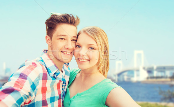 smiling couple taking selfie over bridge Stock photo © dolgachov
