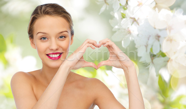 Mosolyog fiatal nő mutat szív alak kézjel szépség Stock fotó © dolgachov