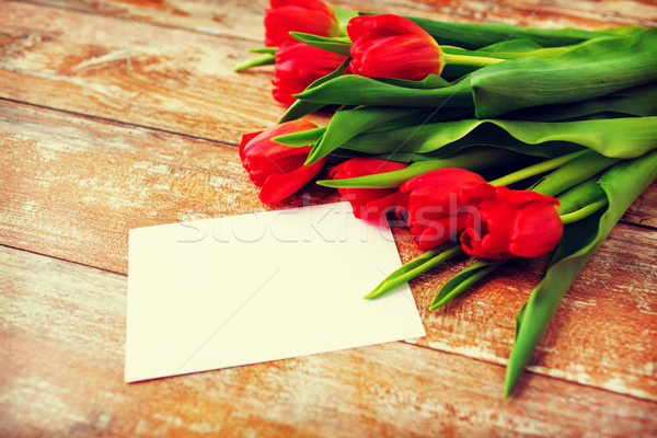 close up of red tulips and blank paper or letter Stock photo © dolgachov