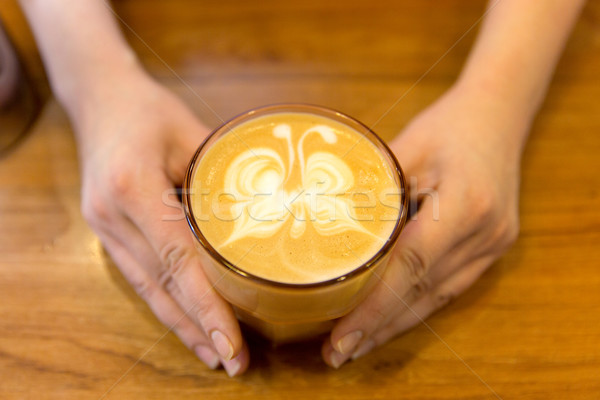 close up of hands with latte art in coffee cup Stock photo © dolgachov