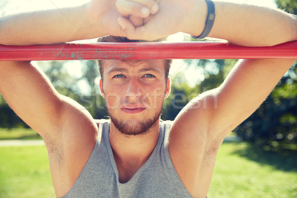 young man exercising on horizontal bar outdoors Stock photo © dolgachov