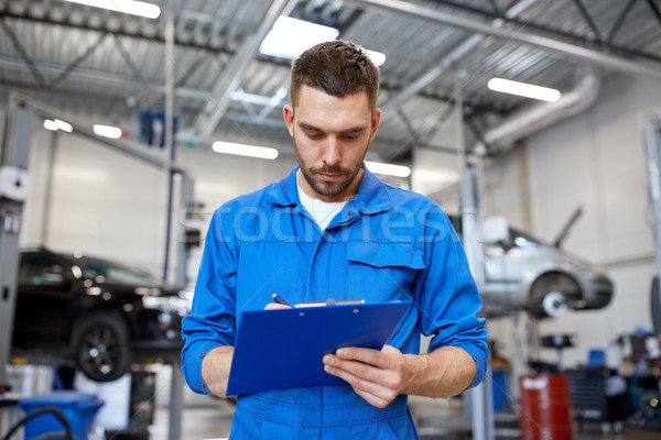auto mechanic man with clipboard at car workshop Stock photo © dolgachov